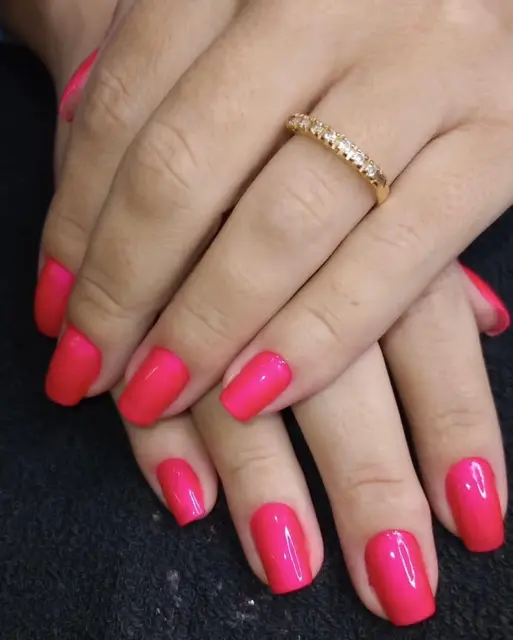 Unhas vermelhas com anel dourado